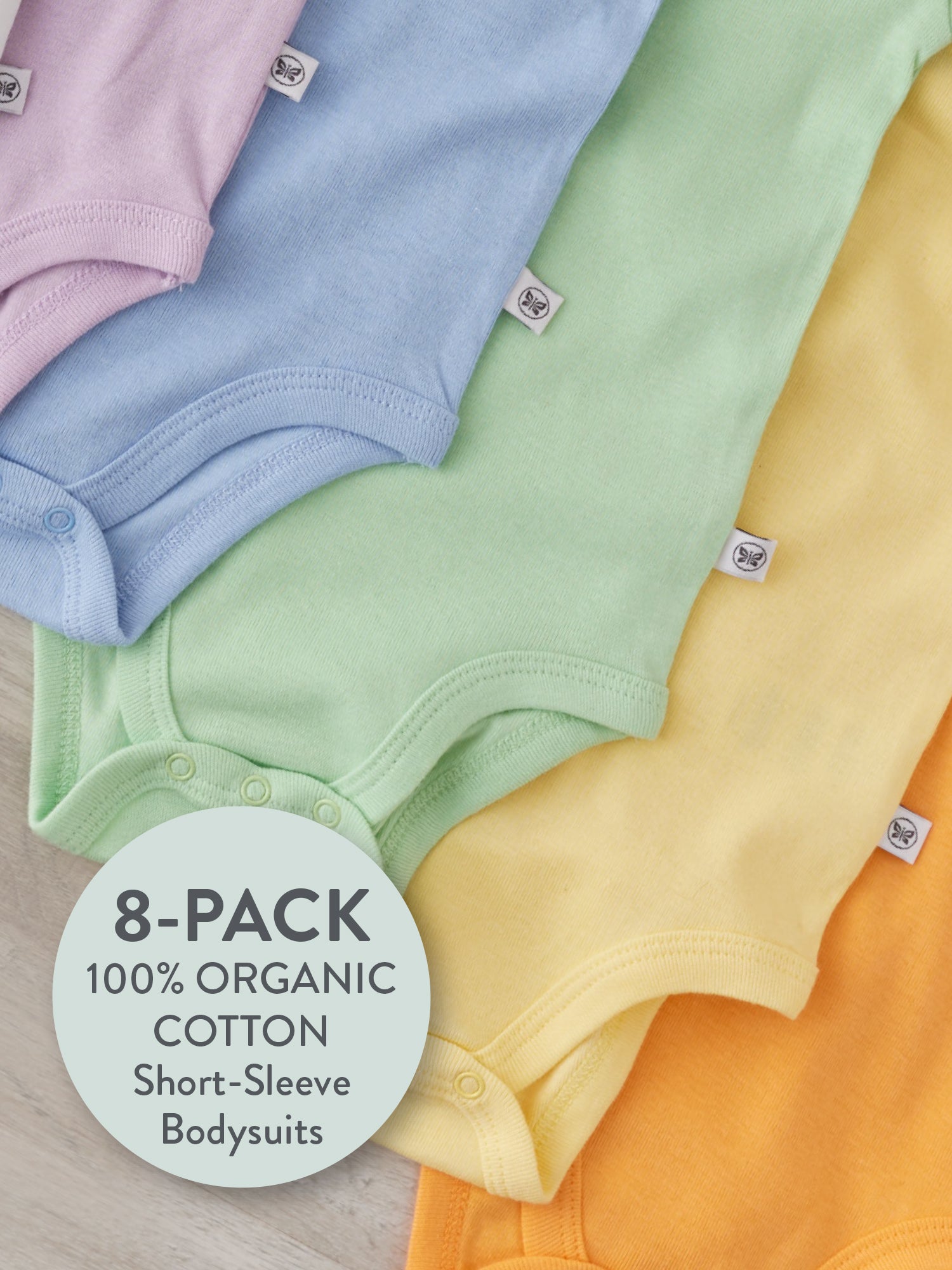 8-pack Honest organic cotton short sleeve baby bodysuits in assorted pastel colors.